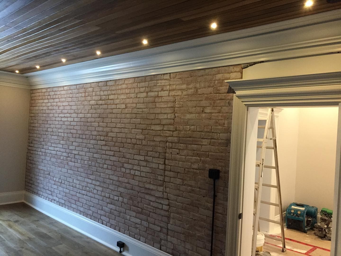Custom wood ceiling with recessed lighting and exposed brick wall by Walkercraft Carpentry